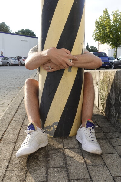 Foto von einer Person, die eine Säule umarmt.