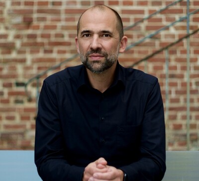 Portrait von Martin Fokken vor einer Backsteinmauer.