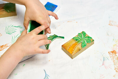 Kinderhände und Stempel in Palmen-Form