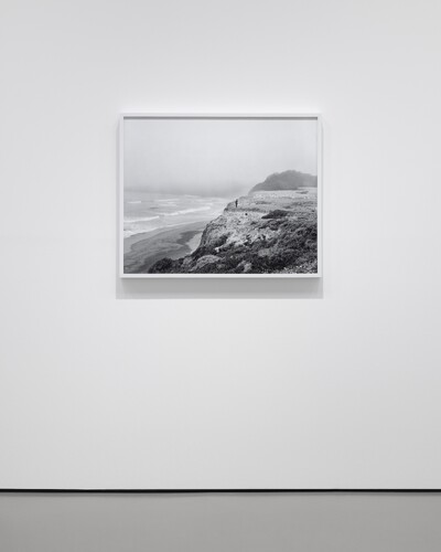 Foto der Fotografie &ldquo;Katy (Sea Ranch)&rdquo; von Catherine Opie, auf der eine Person auf einer Klippe in schwarz wei&szlig; zu sehen ist.