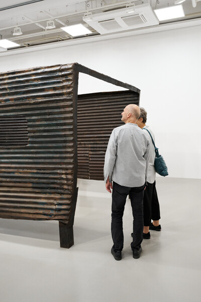 Foto von zwei Menschen, die sich die Skulptur "Untitled" von Robert Grosvenor ansehen.