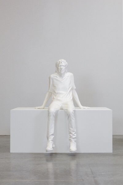 Foto einer Skulptur eines sitzenden Mannes.
