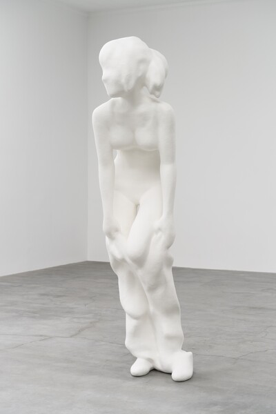 A photo of a sculpture of a person all in white.