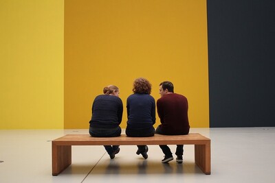 Three people are sitting on a bench.