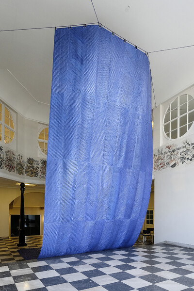 A large blue cloth hangs over two floors in the Hessian State Museum.
