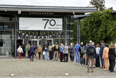 Viele Menschen in einer Schlange vor der documenta Halle.