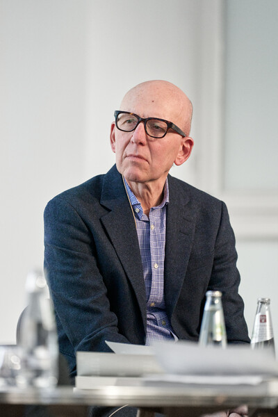Heinz Bude sitzt an einem Tisch und trägt eine große dunkle Brille.