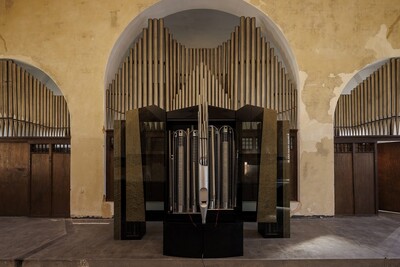 Orgelinstallation mit Metallpfeifen in einer Kirche, frontal fotografiert.