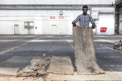 Der K&uuml;nstler Ibrahim Mahama bei der Arbeit mit gebrauchten Jutes&auml;cken