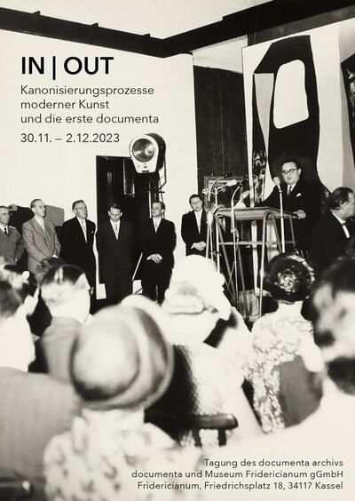 Black and white photo of the opening of the first documenta: A person speaks at a lectern, several people stand behind it, audience in the foreground.