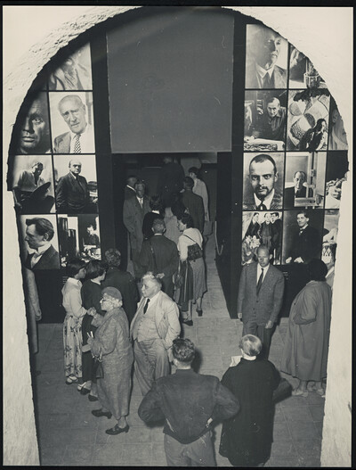 Historische Schwarzweißaufnahme. Menschen unterschiedlichen Alters betreten die Ausstellungsräume