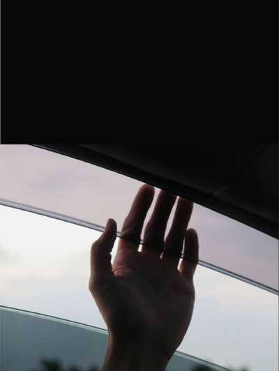 Eine Hand die aus einem Autofenster zeigt.