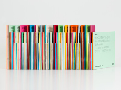 Many colorful notebooks in different sizes placed slightly diagonally next to each other.