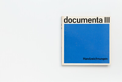 Der Band hat ein quadratisches Cover, das oben einen weißen Balken mit dem Titel „documenta III“ in schwarzer Schrift zeigt. Der untere Bereich ist vollständig blau, unten rechts steht in schwarzer Schrift „Handzeichnungen“. Das Buch liegt auf einem weißen Untergrund.