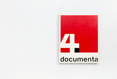 Cover des Ausstellungskatalogs der documenta 4 von 1968. Das grafische Design zeigt eine große weiße Ziffer „4“ vor rotem Hintergrund mit schwarzem Akzent, darunter der Schriftzug „documenta“ in schwarzer serifenloser Schrift auf weißem Grund. Die Gestaltung folgt einem klaren, modernen Raster.