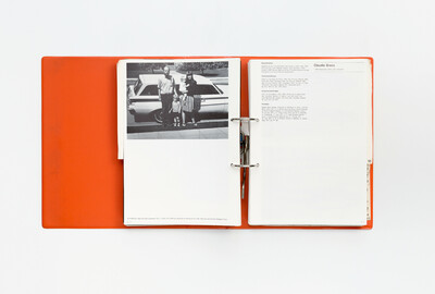 Doppelseite aus dem Ausstellungskatalog der documenta 5 von 1972 in Ringbuchform. Links eine Schwarz-Weiß-Fotografie einer Familie mit zwei Kindern vor einem Auto, aufgenommen auf einem Bürgersteig. Darunter die Werkangabe zum Foto. Rechts eine Biografieseite mit Informationen über den Künstler Claudio Bravo, seine Herkunft, Ausstellungen und Sammlungen, in denen seine Werke vertreten sind. Die Gestaltung ist schlicht und typografisch geprägt.