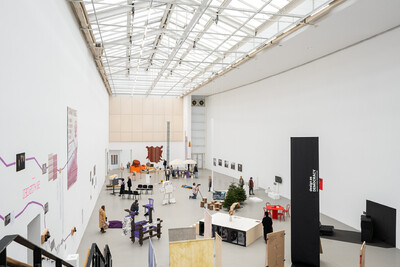 Innenansicht der documenta Halle, in der verschiedene Kunstobjekte im Rahmen einer Ausstellung präsentiert werden.