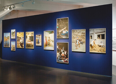 Fotoinstallation die inszenierte Porträts im ländlichen Indien zeigt, die Personen auf den Bildern tragen Masken.