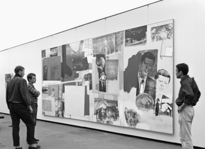 Drei Männer stehen vor einem großem Kunstwerk.