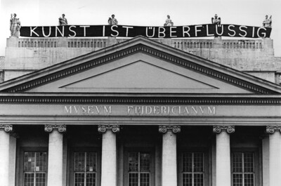 Dach des Fridericianum mit Banner. Auf dem Banner steht "Kunst ist überflüssig"