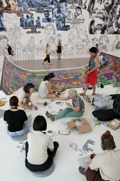 Eine Gruppe von Menschen gestaltet Kunstwerke auf dem Boden.