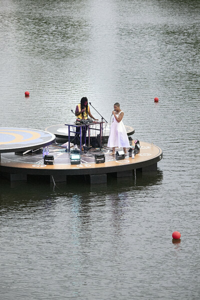 Ein Konzert auf einer schwimmenden Bühne mit zwei Performenden.